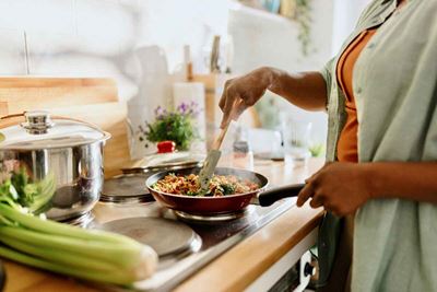 woman cooking food on the stove