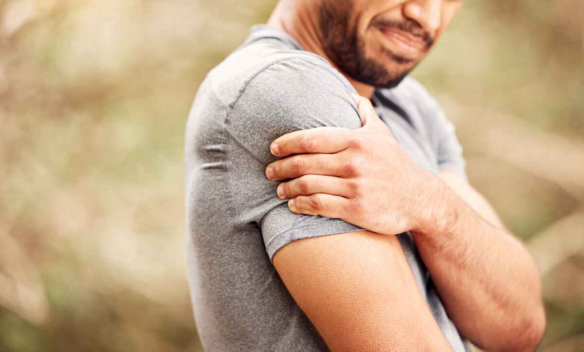 Man holds shoulder in pain