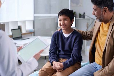 Boy and parent talk with doctor 