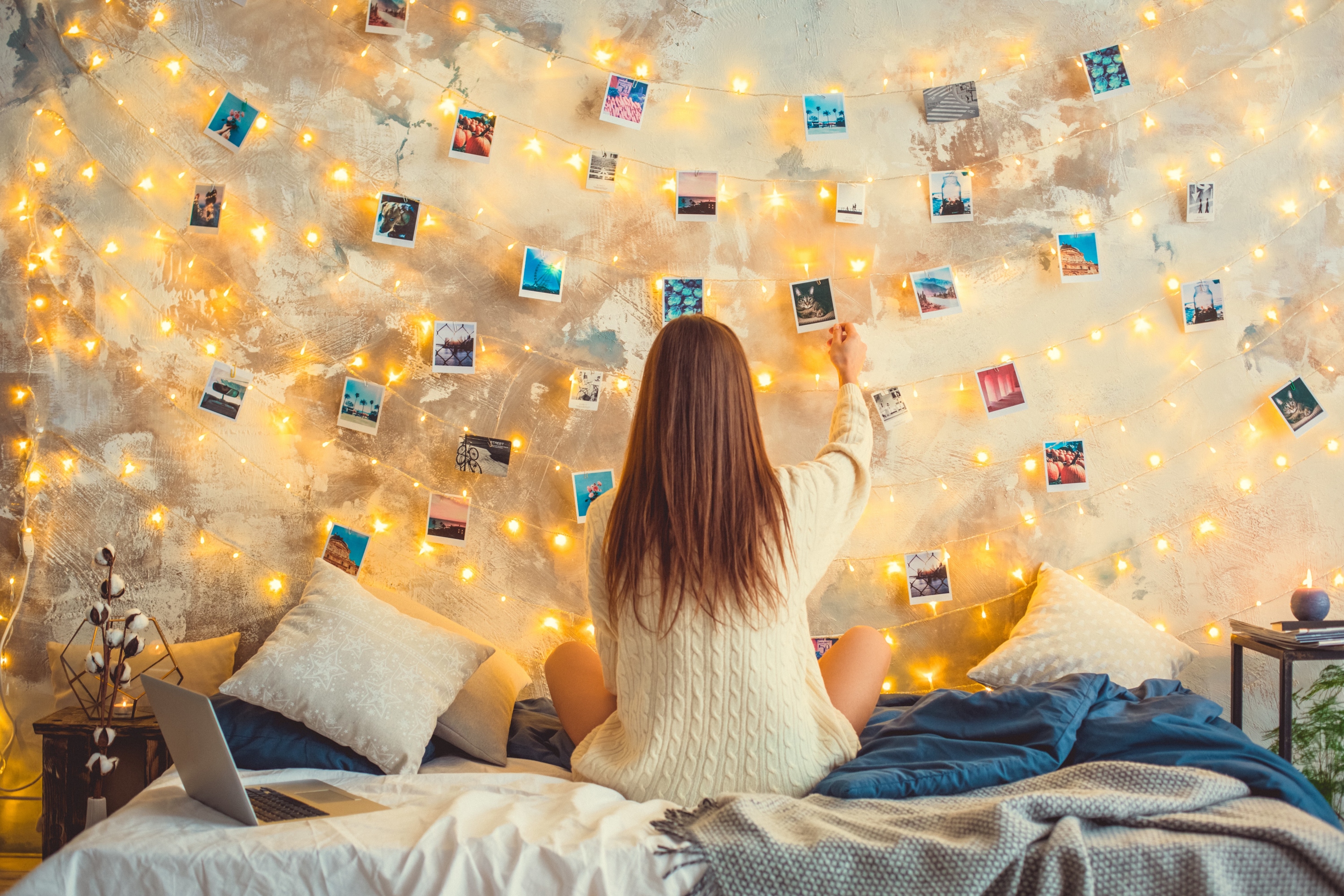 teenager hanging photos on her wall