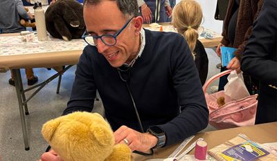 Anthony Porto, MD giving a teddy bear a check  up